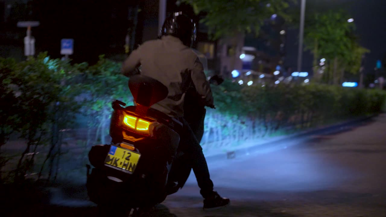 Scooter bij nacht met fel achterlicht