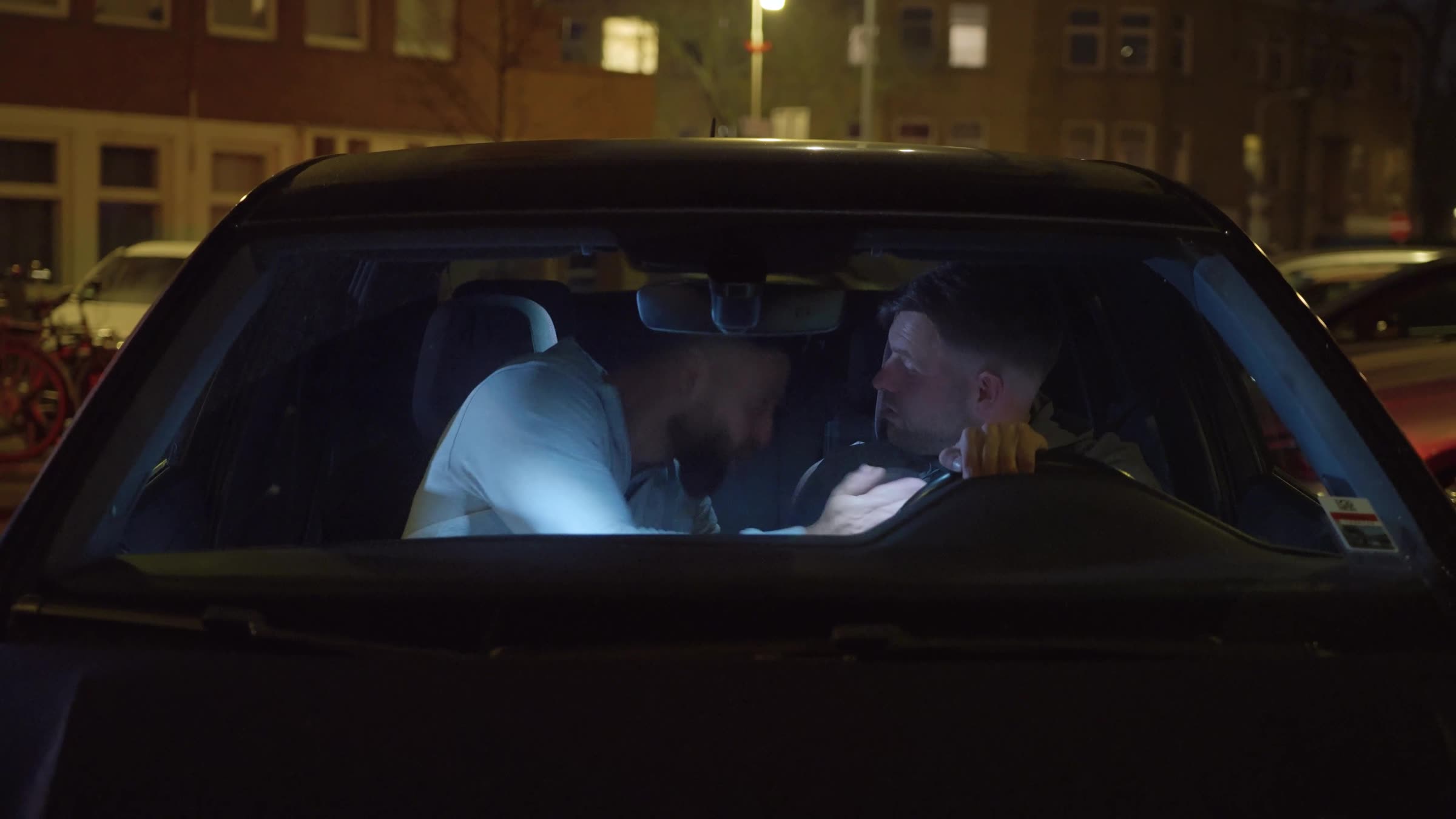 Still uit de trailer: twee mannen in een geparkeerde auto bij nacht